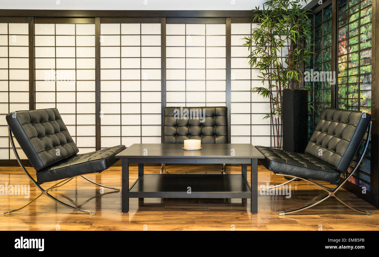 Contemporary Japanese Room with tea table, candle and three black lounge chairs Stock Photo