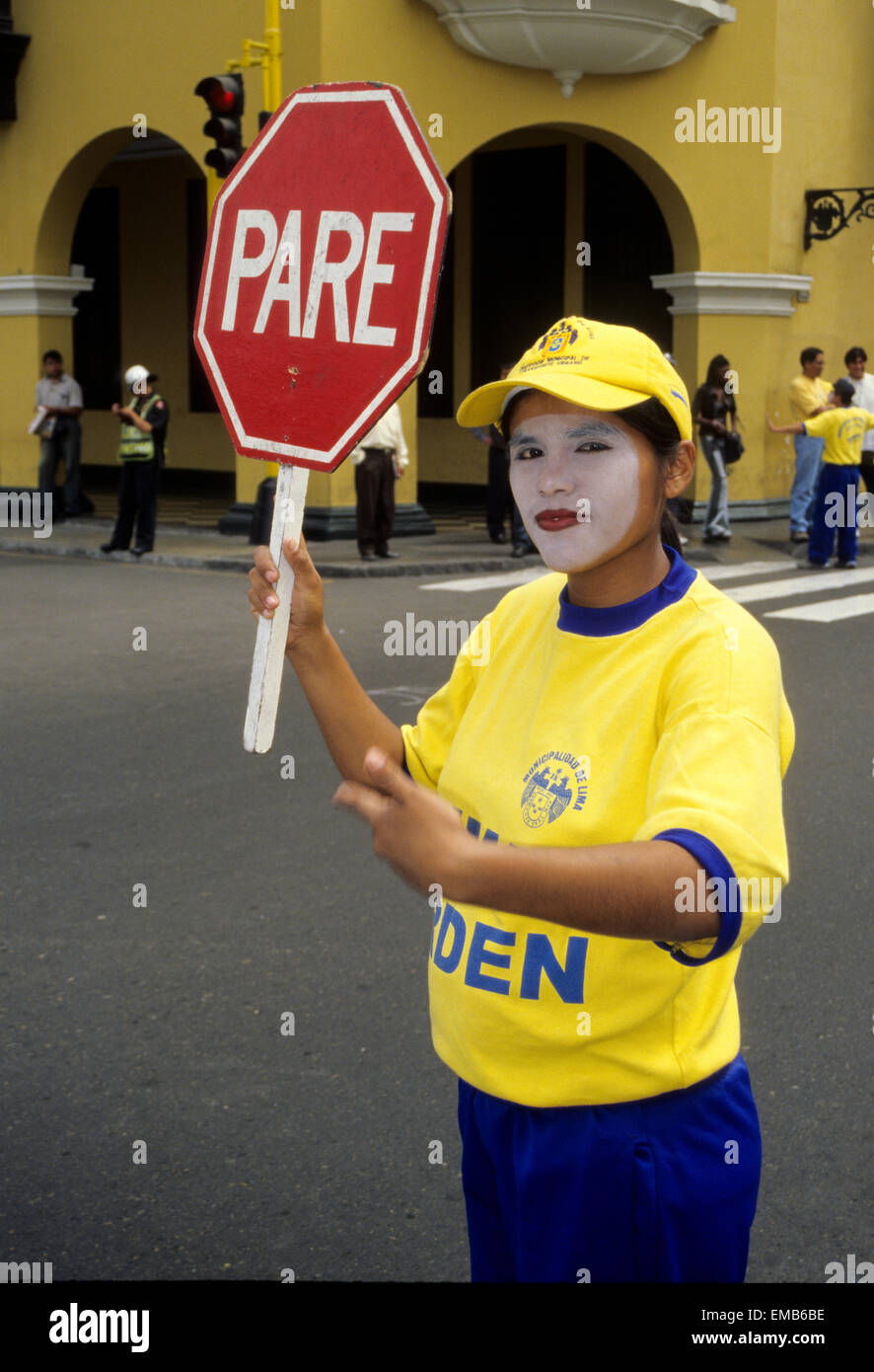 Peru, Lima. Traffic Policewoman Stops Traffic to Allow Tourists to Cross.  Plaza de Armas. Stock Photo