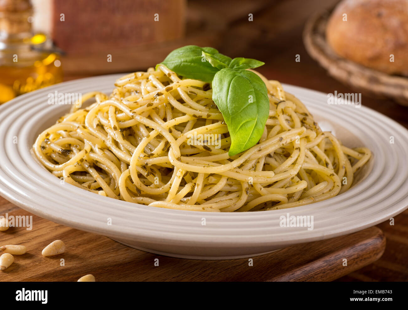 A delicious bowl of fresh spaghetti with green basil pesto sauce. Stock Photo