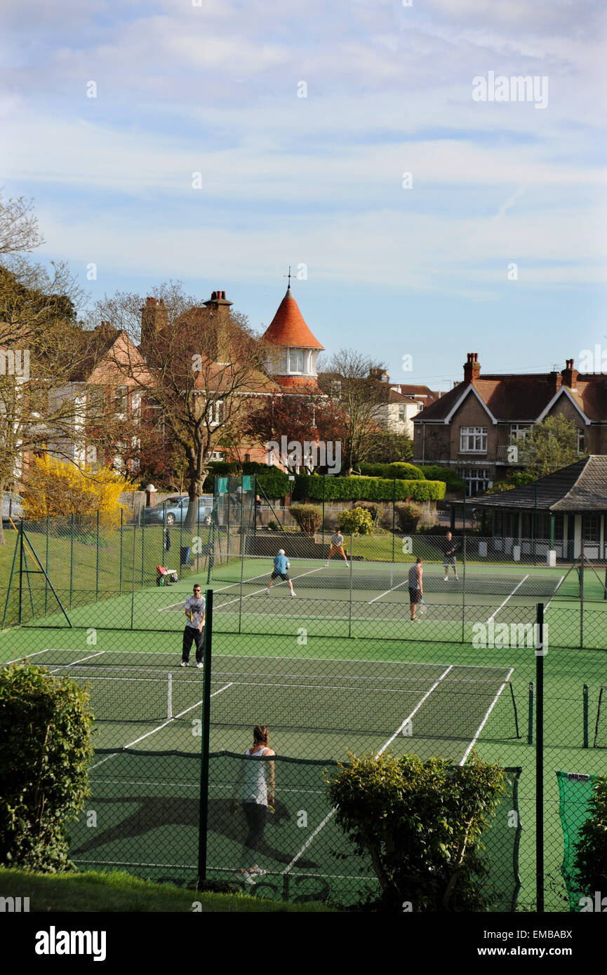 Brighton Sussex UK  - Tennis players enjoy the lovely weather on the Queens Park courts in Brighton this afternoon Photograph taken by Simon Dack/Alamy Live News Stock Photo