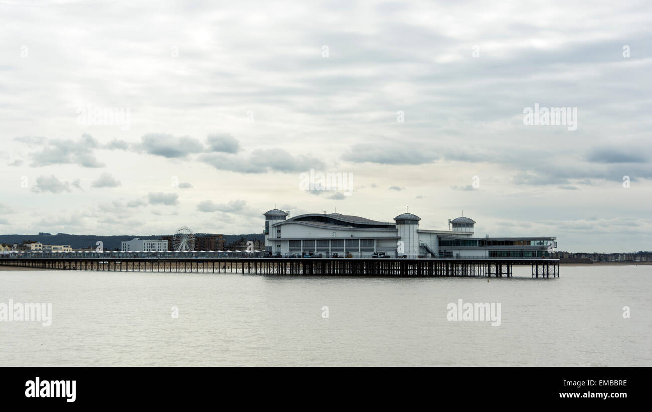 The Grand Pier at Weston-super-Mare at high tide with a few fluffy clouds in the sky above it. Stock Photo