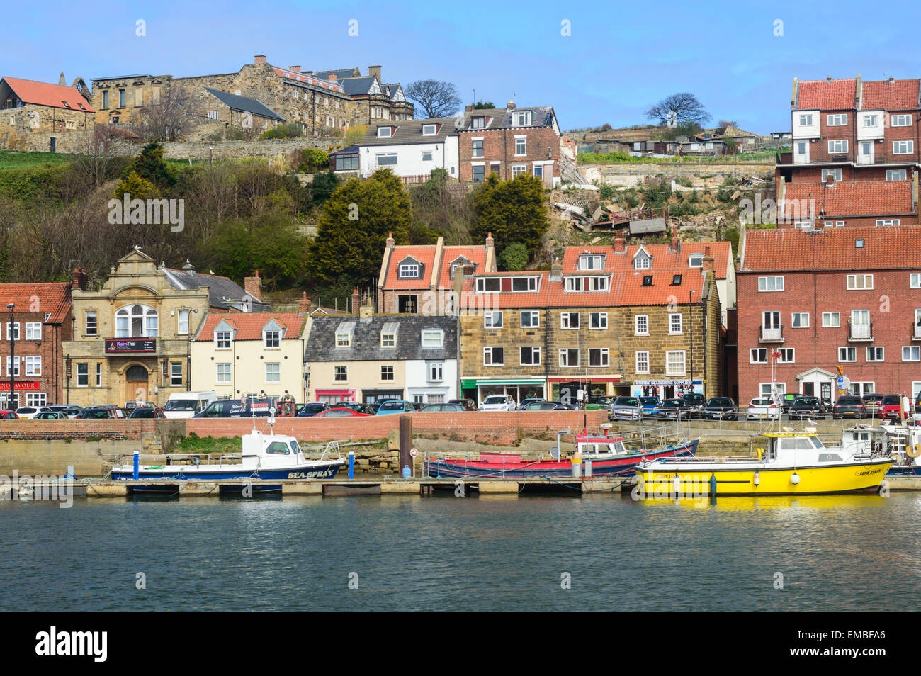 Whitby harbour, boats, and houses on Church Street, in Whitby, North