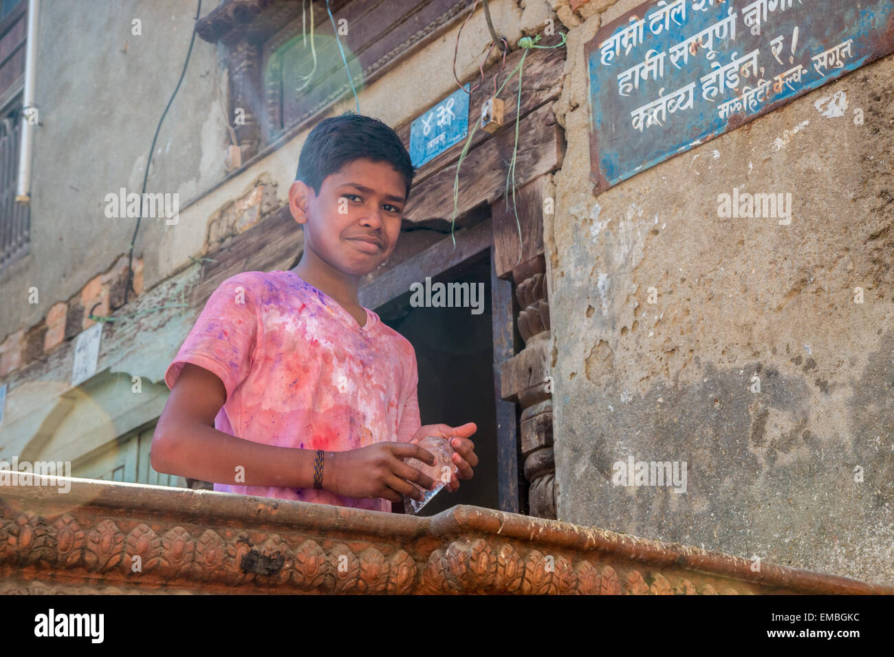 A young boy is smiling at the camera during holi festival in Kathmandu Stock Photo