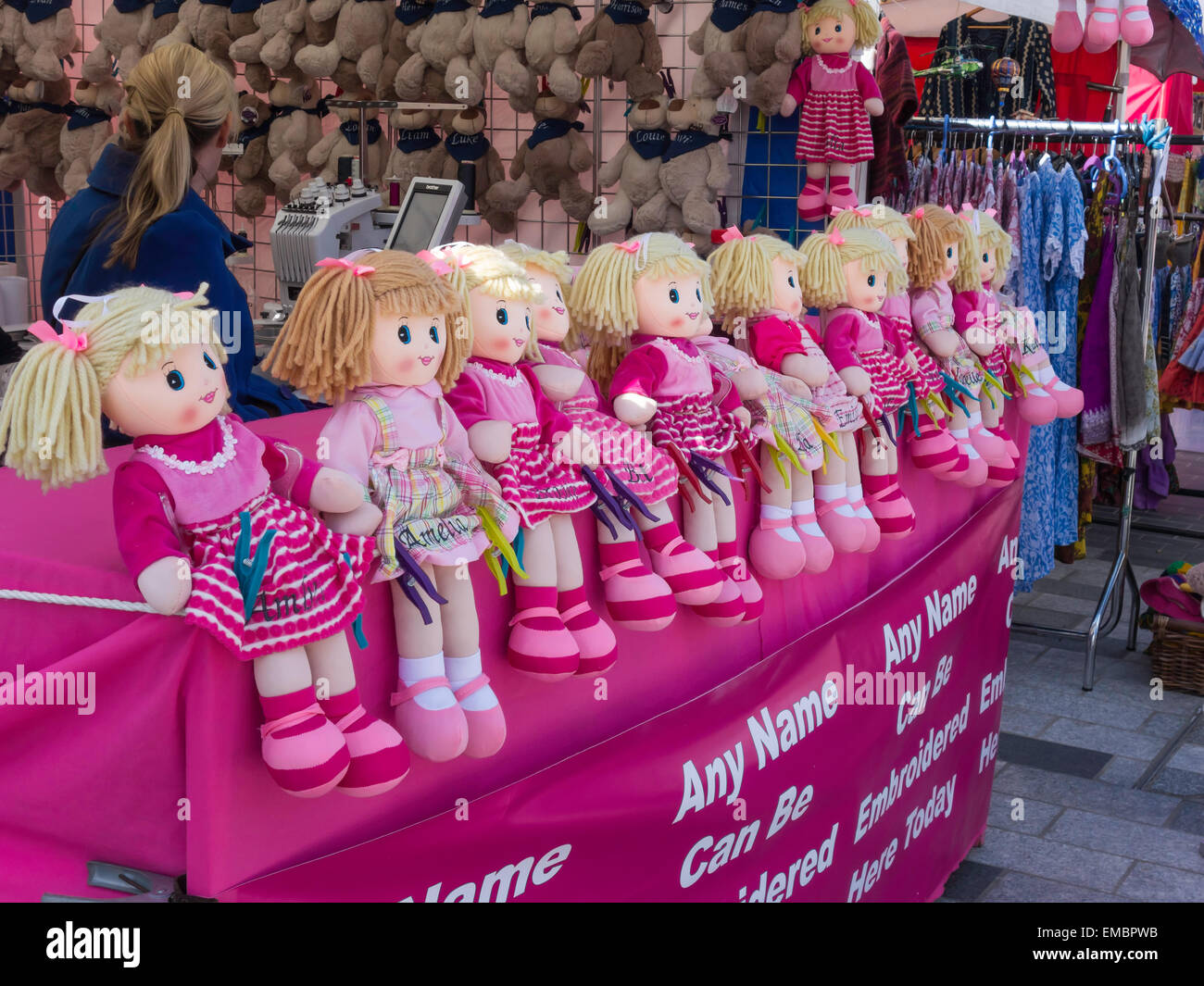 A display of toy pink rag dolls on a market stall where a name may be embroidered on them. Stock Photo