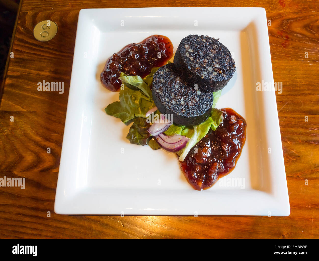 Pub Sunday lunch first course fried Black Pudding with salad and apple and plum chutneys Stock Photo