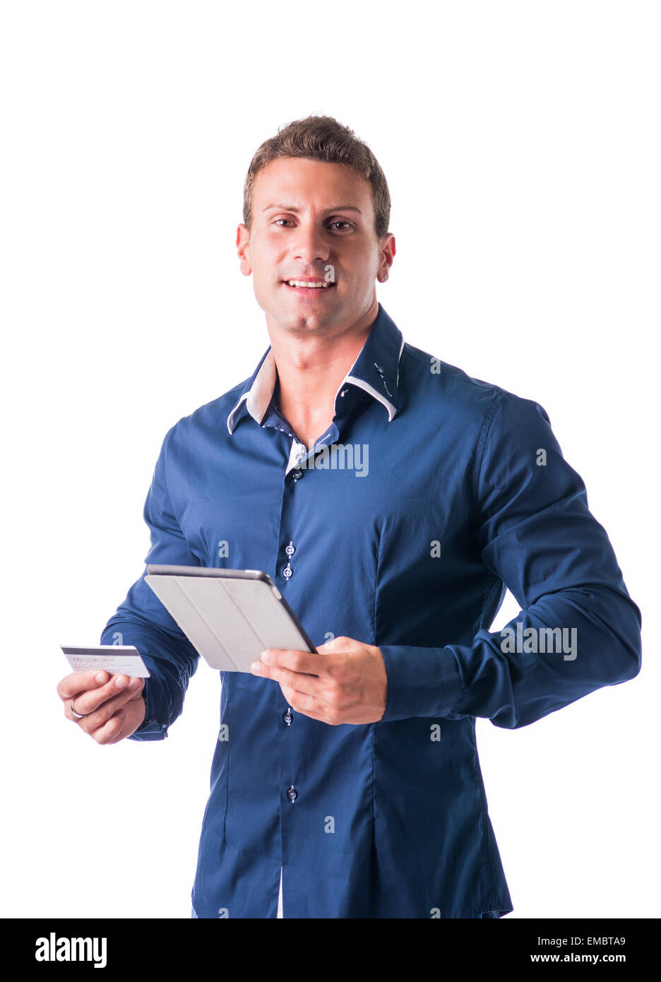 Young Businessman Holding a Credit Card and Tablet Computer, Verifying Some Information for an Electronic Transactions or Buying Stock Photo