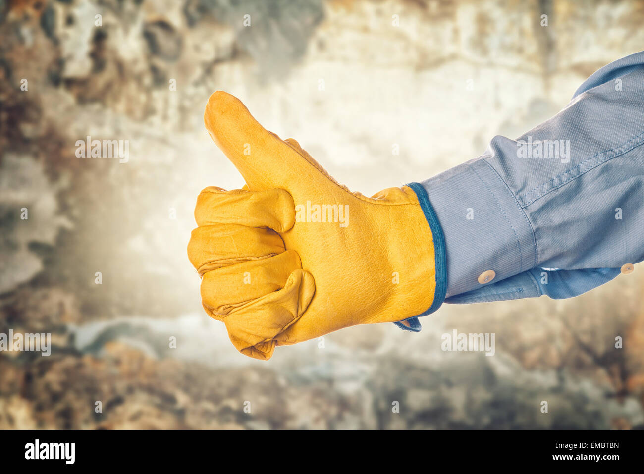 Construction Engineer Wearing Yellow Leather Protective Gloves Gesturing Thumbs Up for Approval Stock Photo