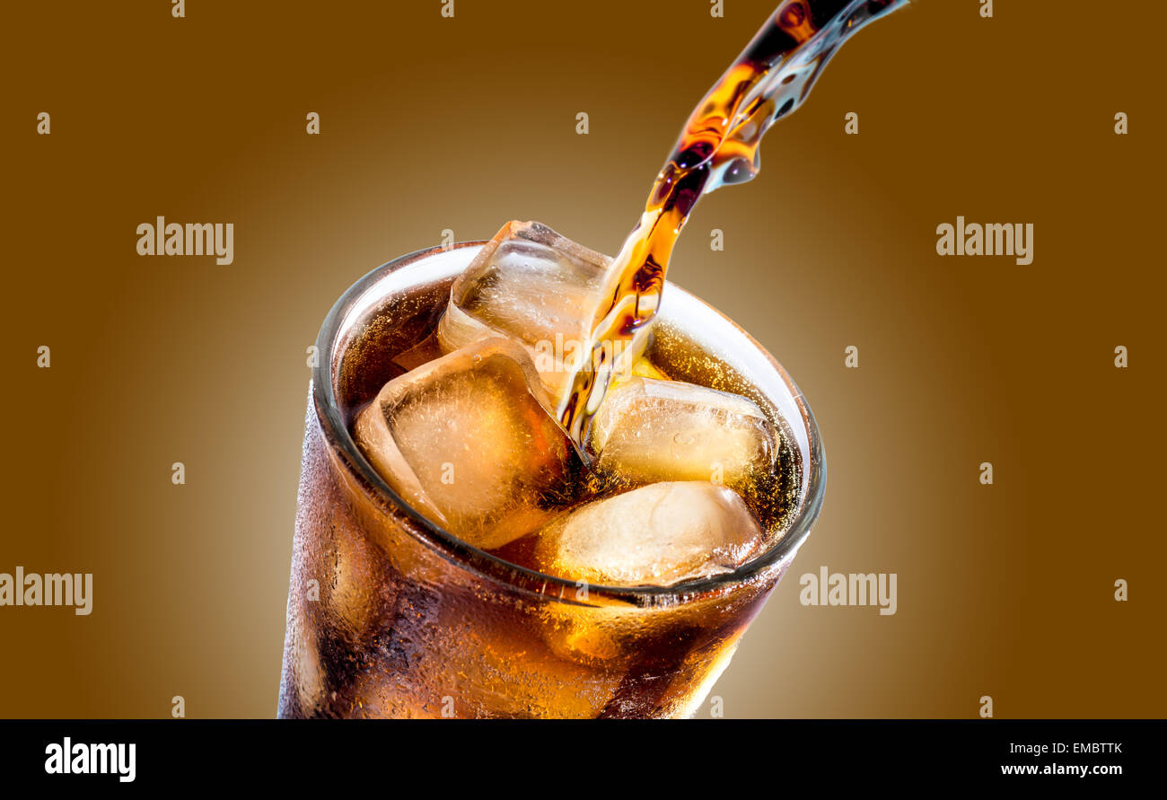 Cola drink splash with ice cube on brown background Stock Photo - Alamy
