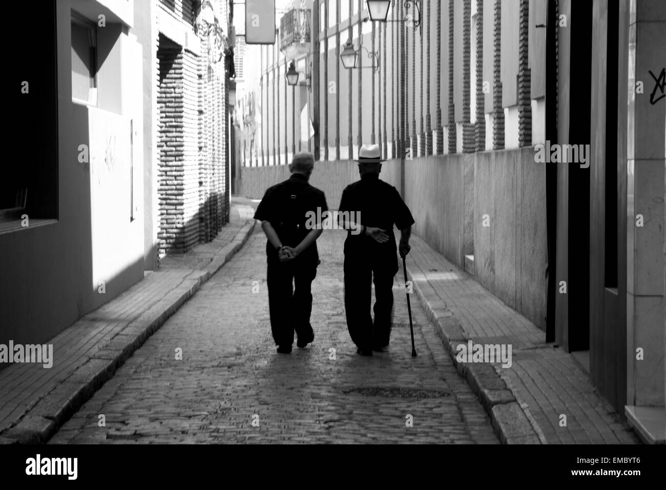 Two elder priests walk along a street in Cordoba, Spain Stock Photo