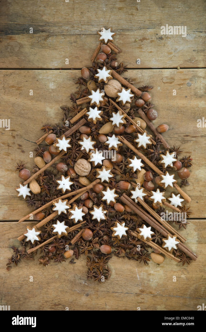 Christmas tree shaped of cinnamon stars nuts, almonds, cinnamon sticks and star anise Stock Photo