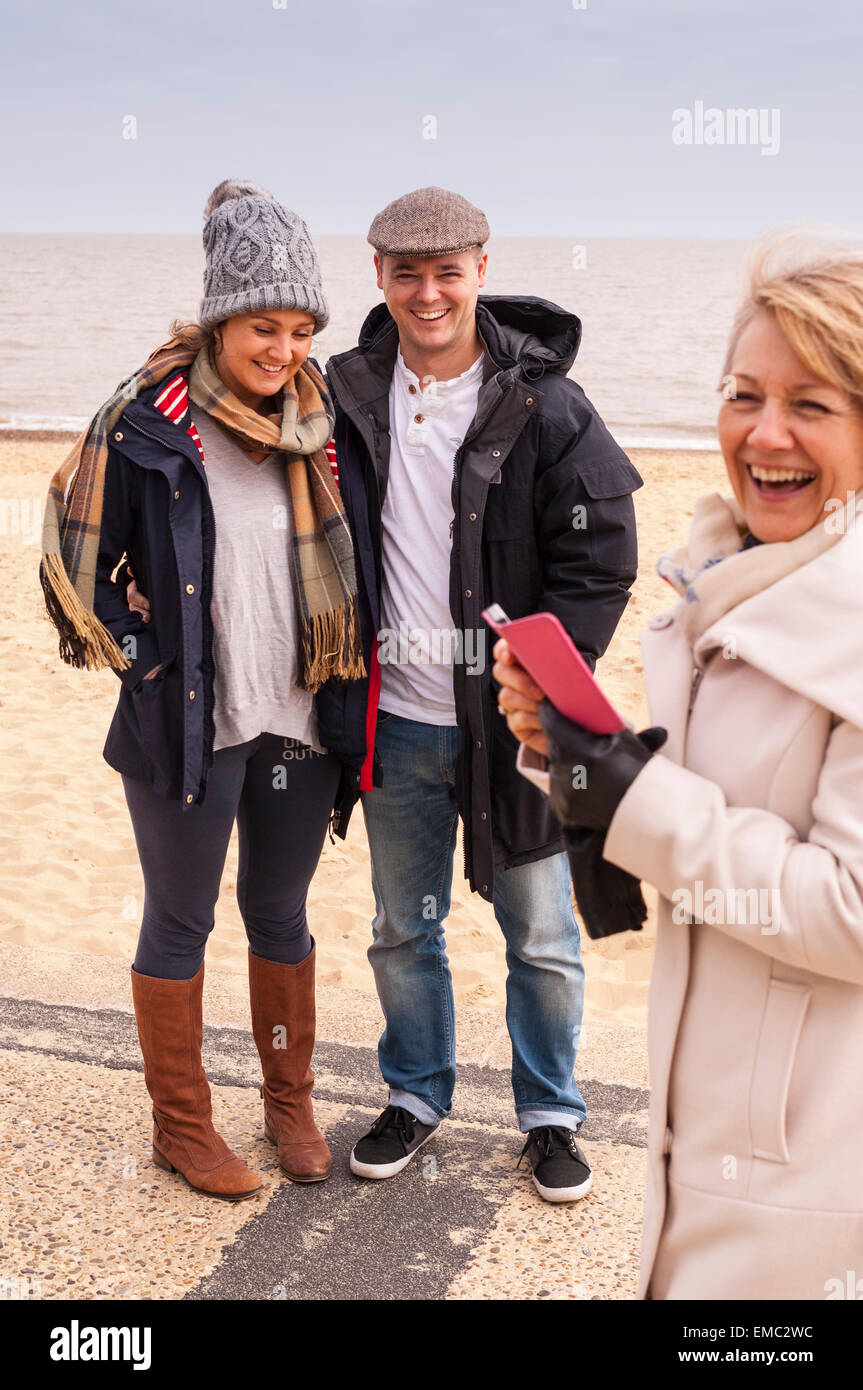 A woman taking a family pic on her phone in Southwold , Suffolk , England , Britain , Uk Stock Photo