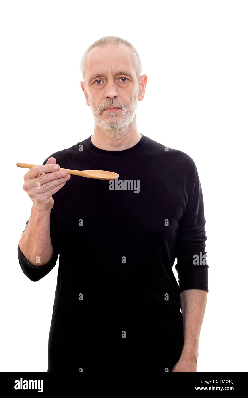 Adult man in black holds a spoon in each and looks serious Stock Photo