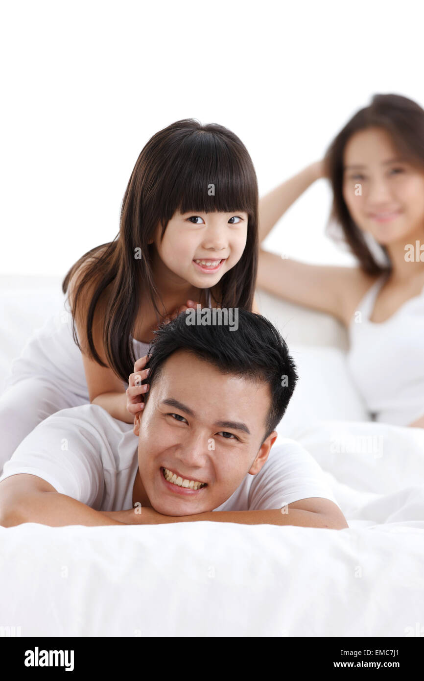 A family of three in the bed of the bedroom to play Stock Photo