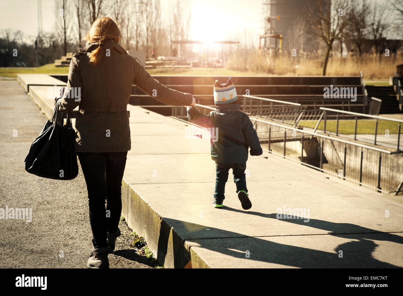 Germany, Oberhausen, toddler walking with mother in park Stock Photo