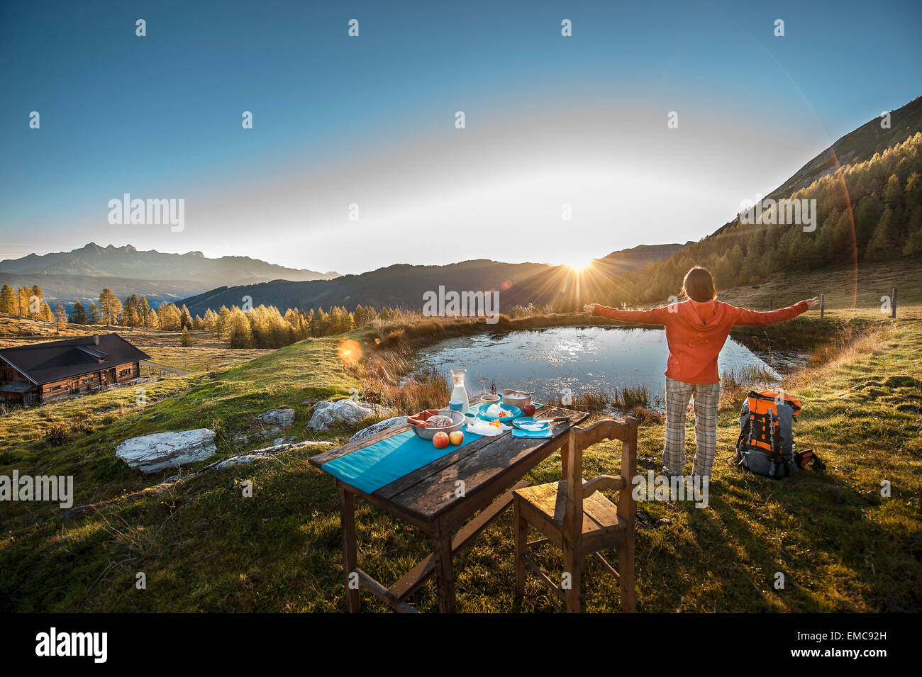 Austria, Altenmarkt-Zauchensee, young woman in the mountains at sunrise Stock Photo