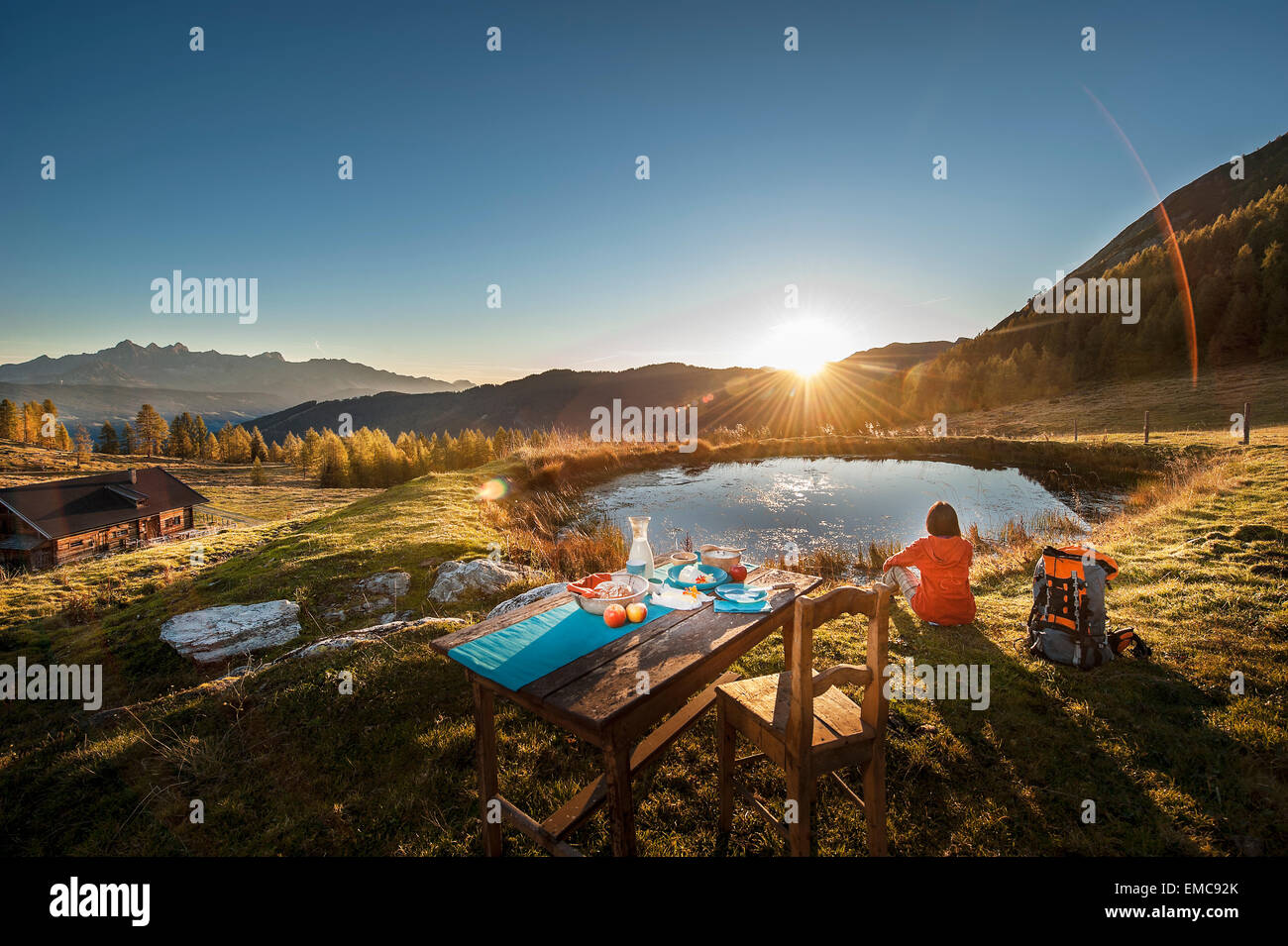 Austria, Altenmarkt-Zauchensee, young woman in the mountains at sunrise Stock Photo