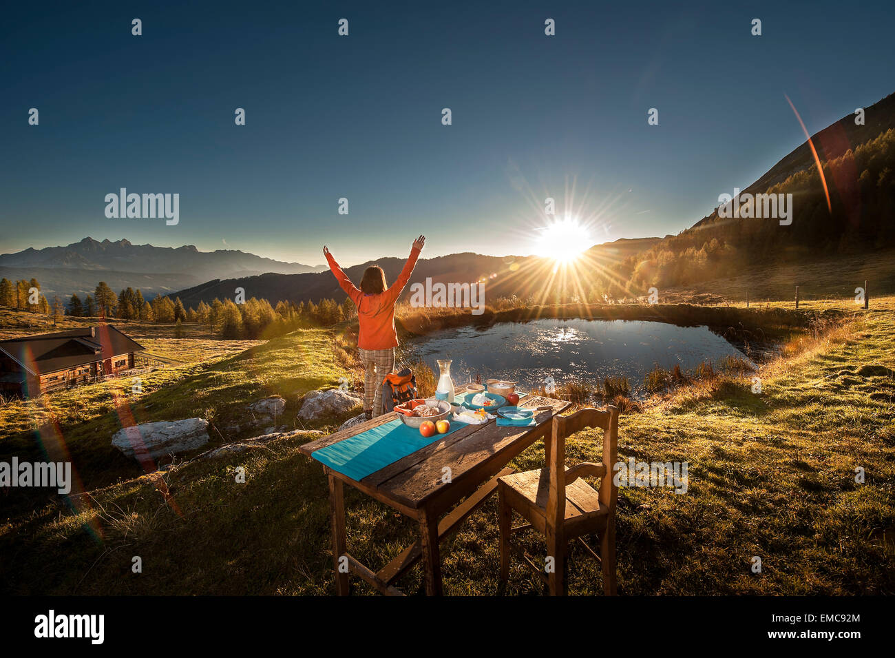Austria, Altenmarkt-Zauchensee, young woman in the mountains at sunrise Stock Photo