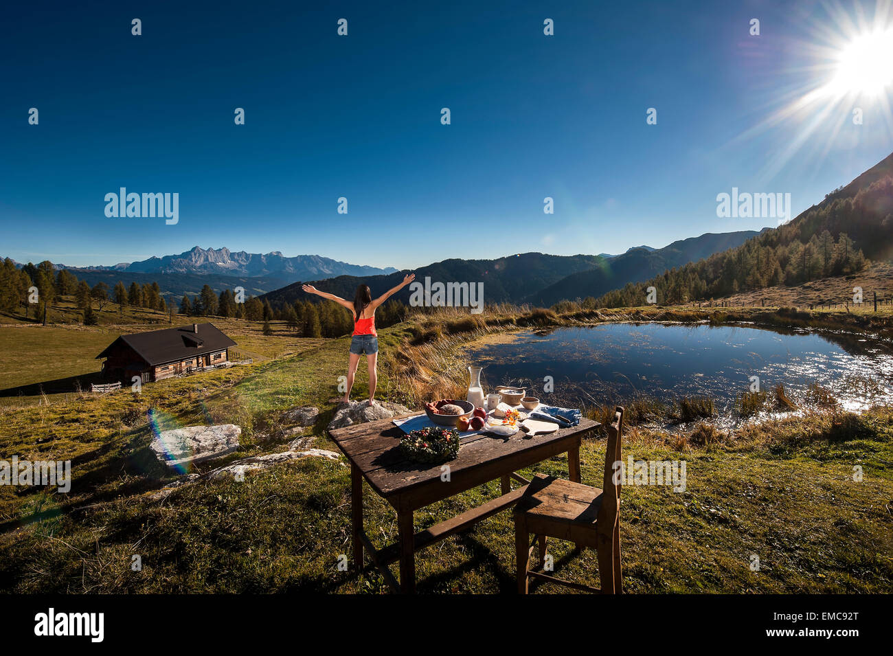 Austria, Altenmarkt-Zauchensee, young woman in the mountains at sunrise Stock Photo