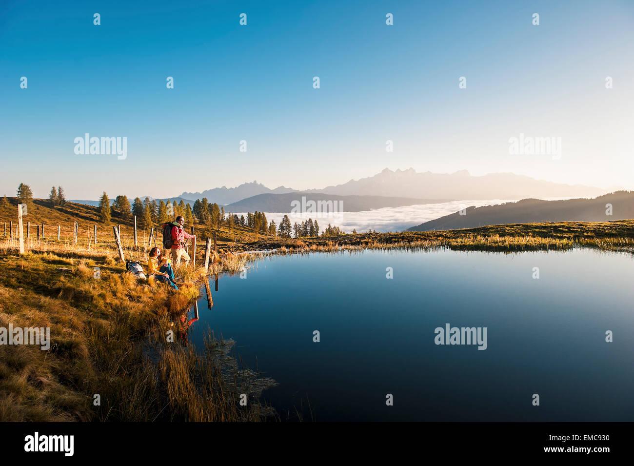 Austria, Altenmarkt-Zauchensee, young couple at mountain lake in the Lower Tauern Stock Photo