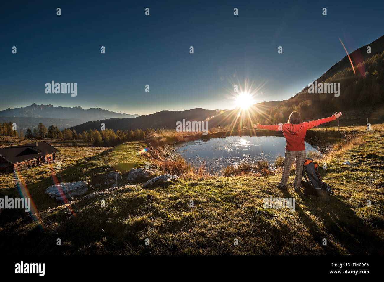 Austria, Altenmarkt-Zauchensee, young woman in the mountains at sunrise Stock Photo