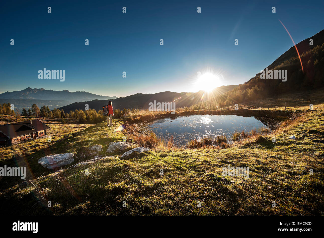 Austria, Altenmarkt-Zauchensee, young woman in the mountains at sunrise Stock Photo