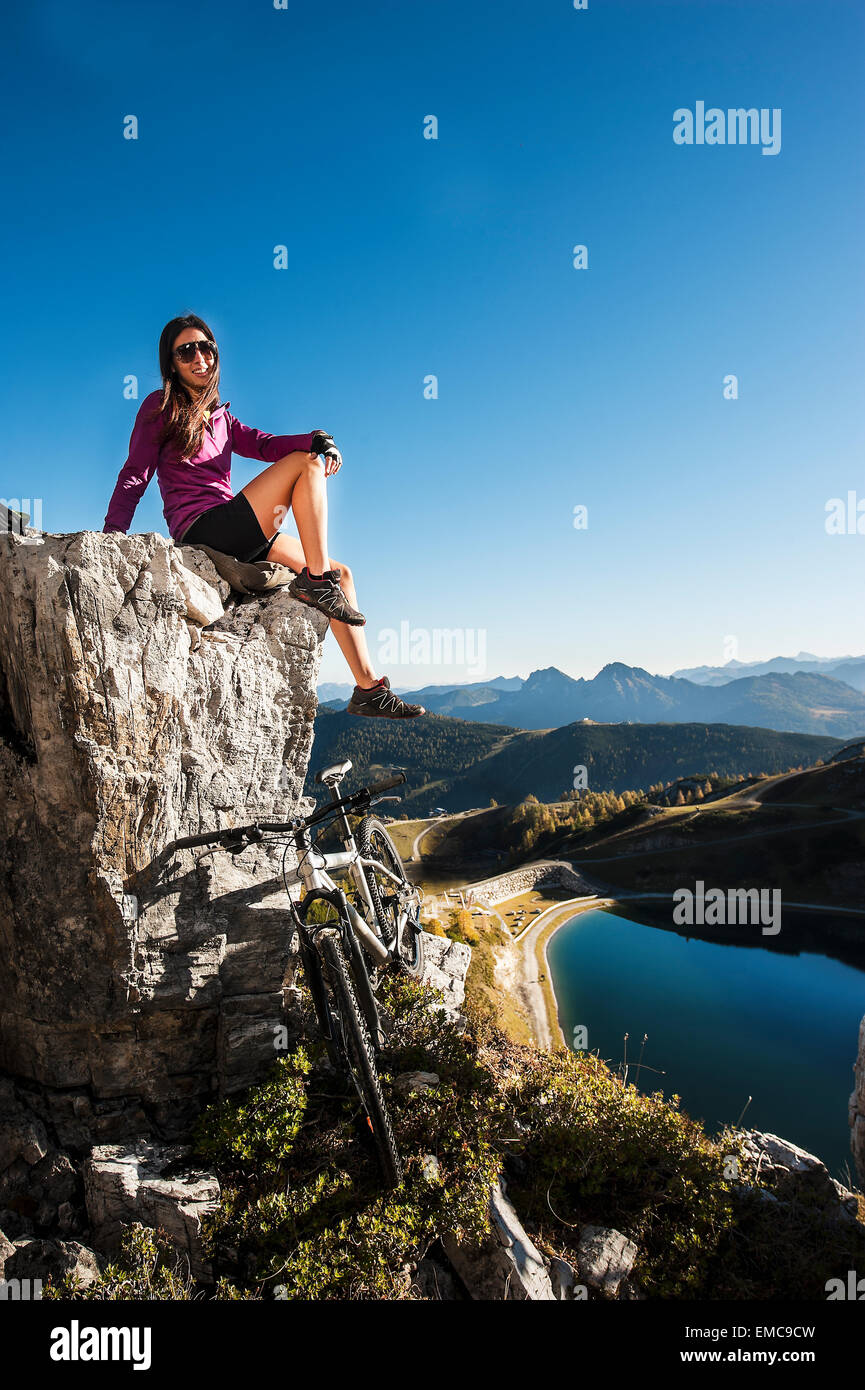 Austria, Altenmarkt-Zauchensee, young woman with mountain bike in the mountains Stock Photo