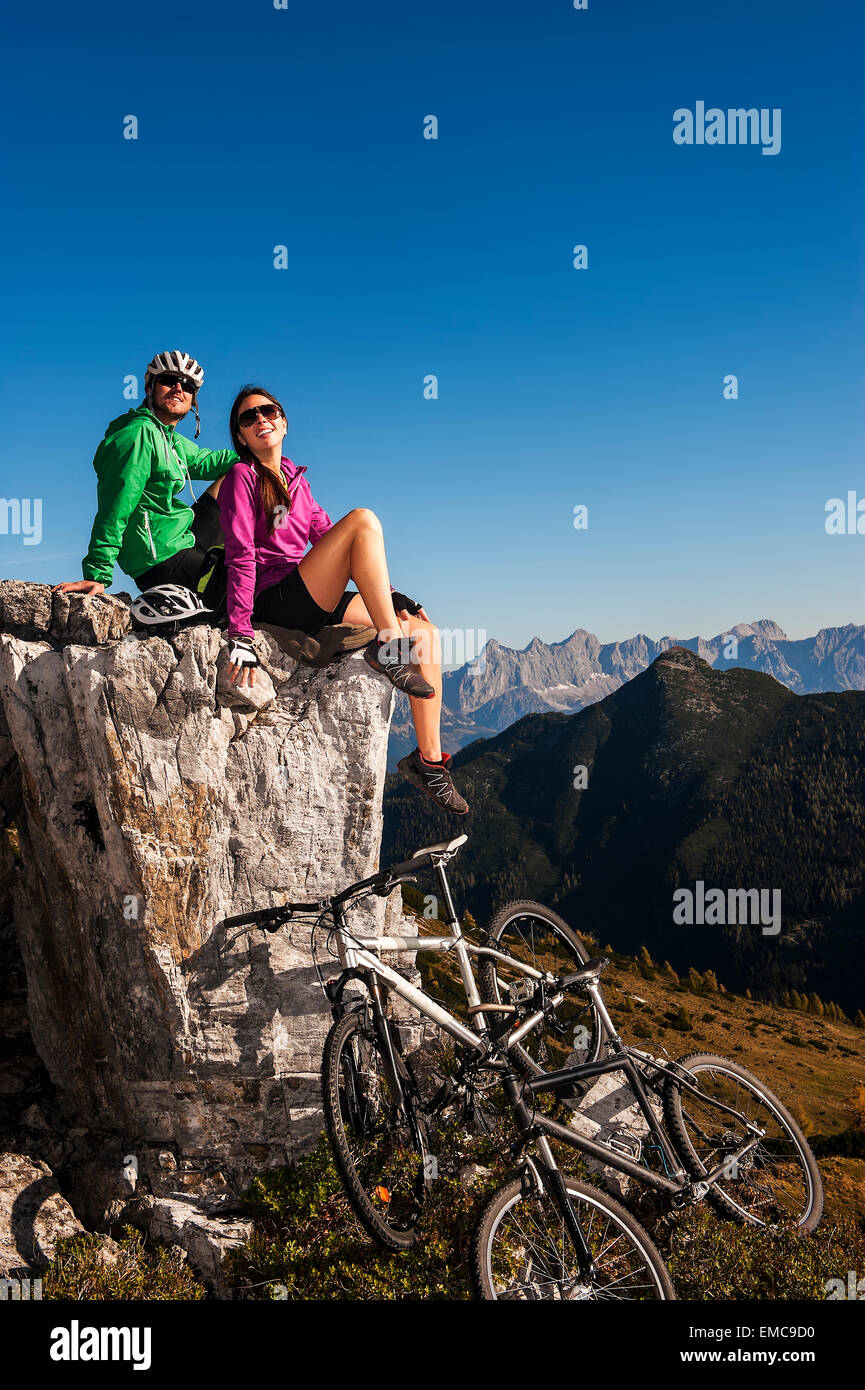 Austria, Altenmarkt-Zauchensee, young couple with mountain bikes in the mountains Stock Photo