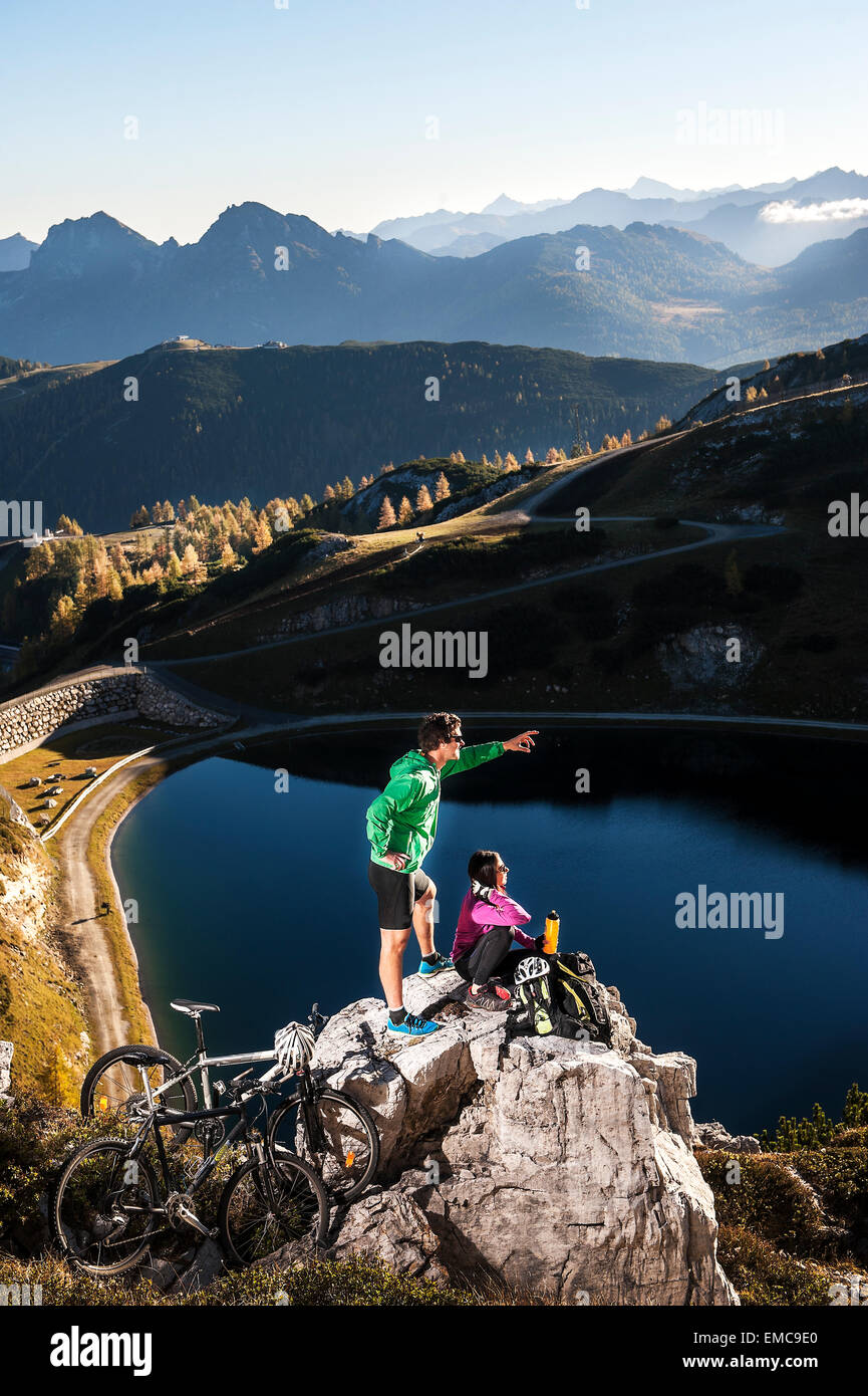 Austria, Altenmarkt-Zauchensee, young couple with mountain bikes in the mountains Stock Photo