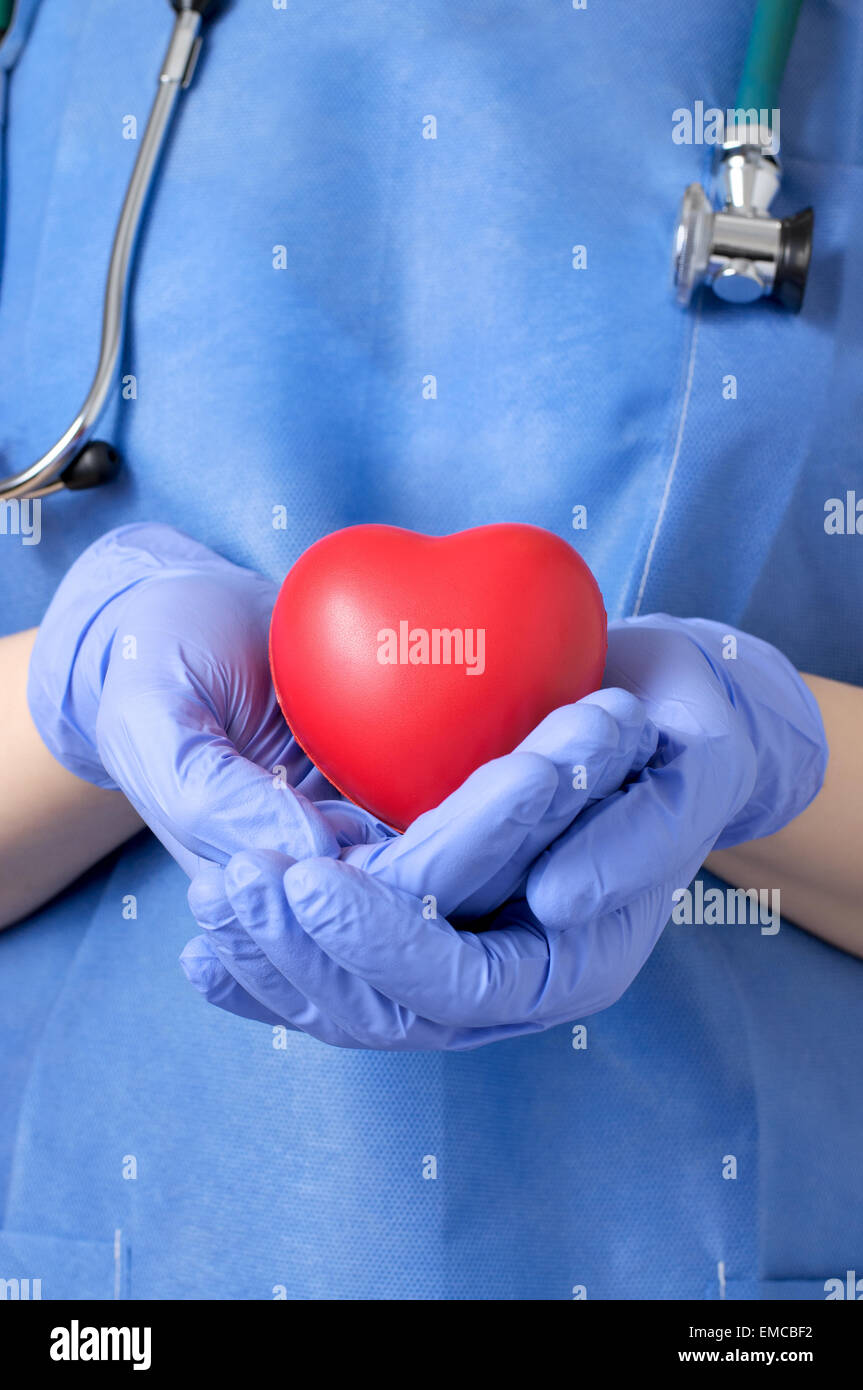Female doctor holding a red heart shape Stock Photo - Alamy