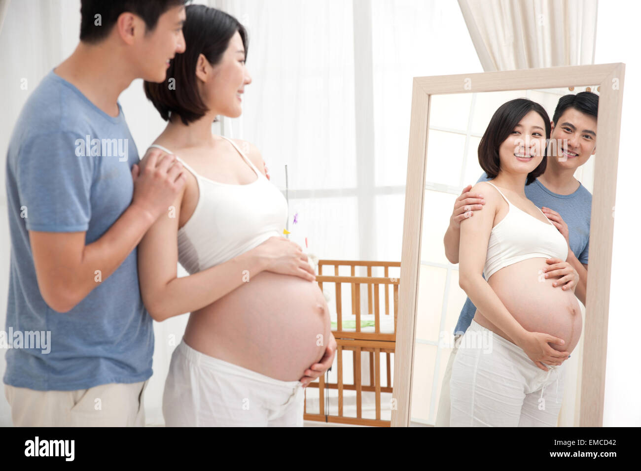 The young couple standing in front of the mirror Stock Photo