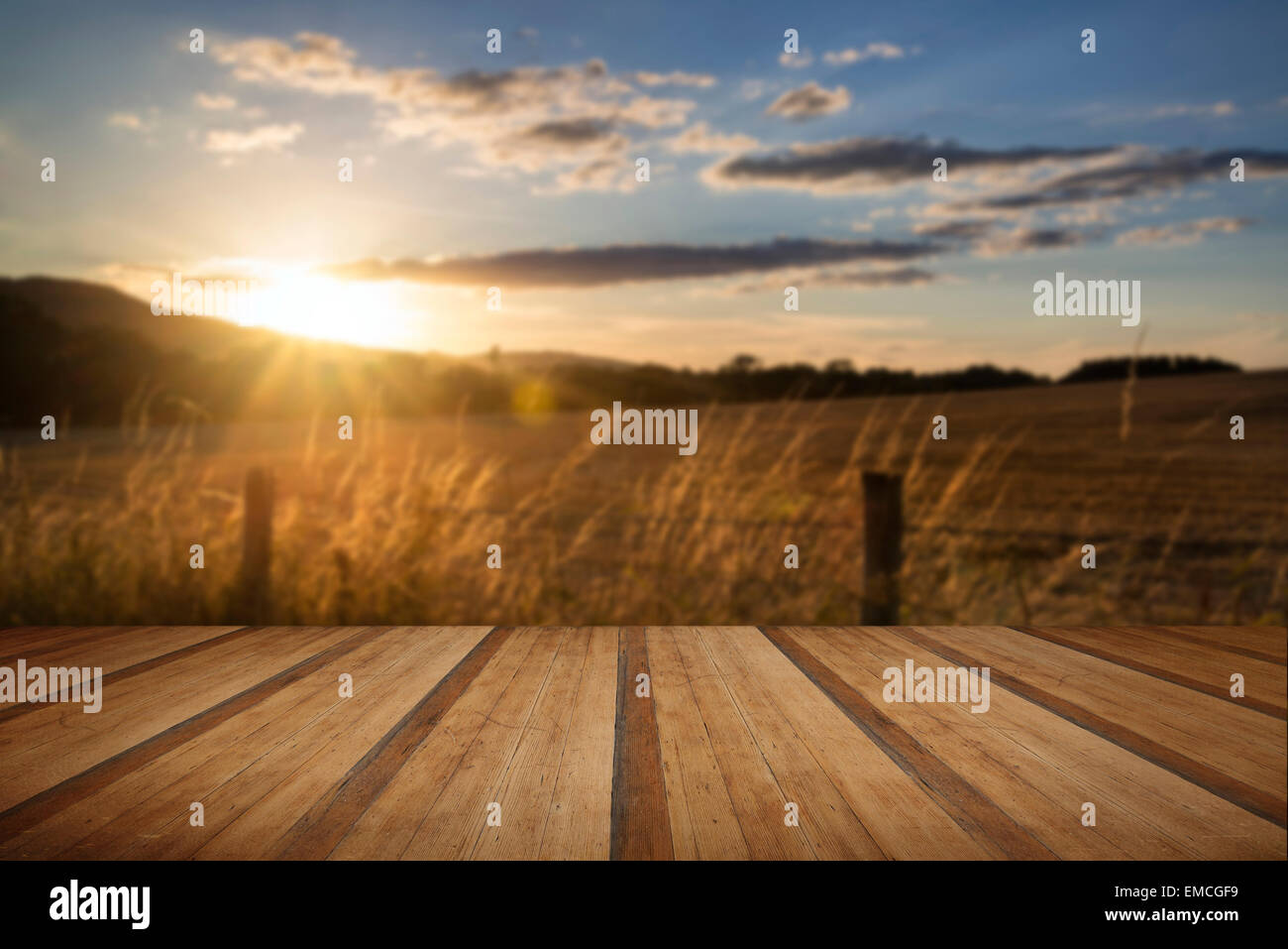 Beautiful Summer image of sun shining and backlighting countryside landscape with wooden planks floor Stock Photo