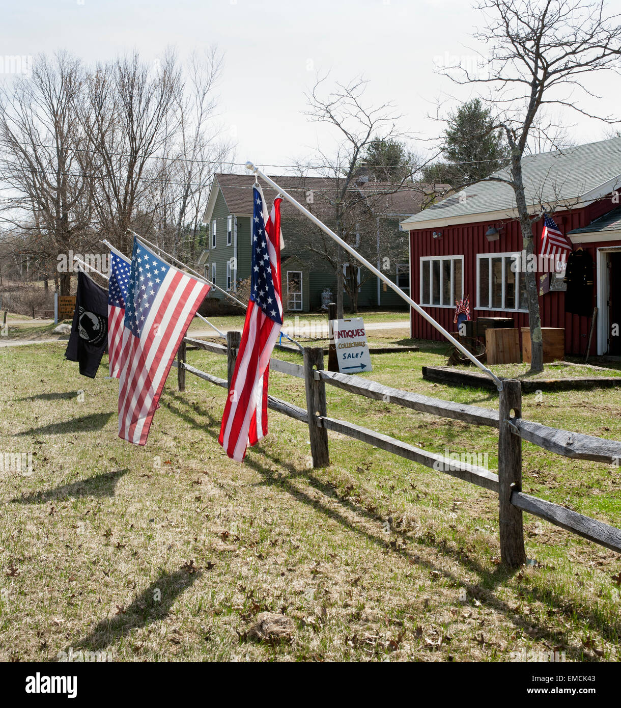 Flags fly in front of a roadside antique store in Vermont on a sunny spring day. Stock Photo
