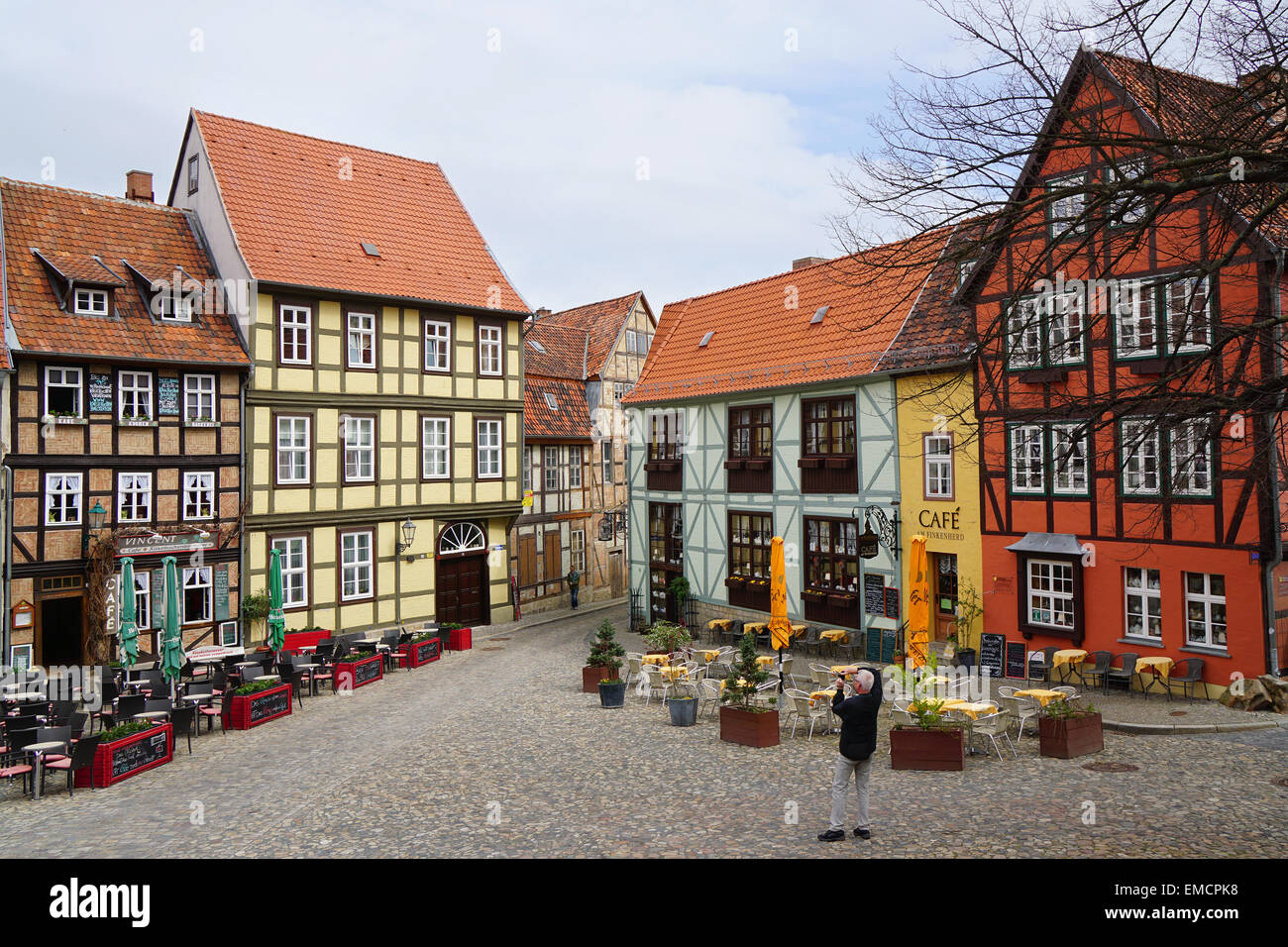 Quedlinburg, Germany - April 16, 2015: Tourist taking photograph of the colorful half-timbered houses on Schlossberg. Stock Photo