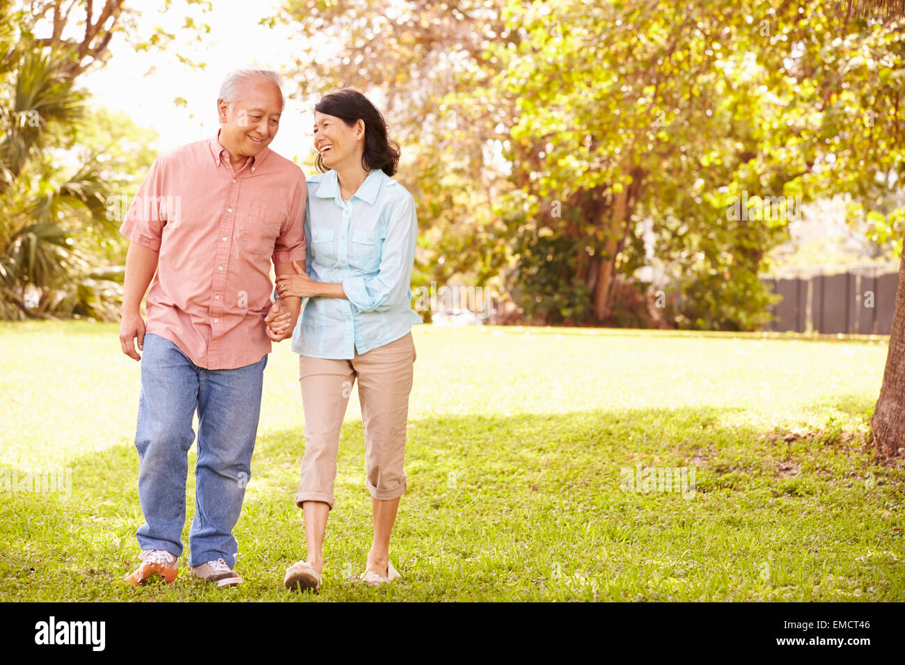 Senior Asian Couple Walking Through Park Together Stock Photo - Alamy
