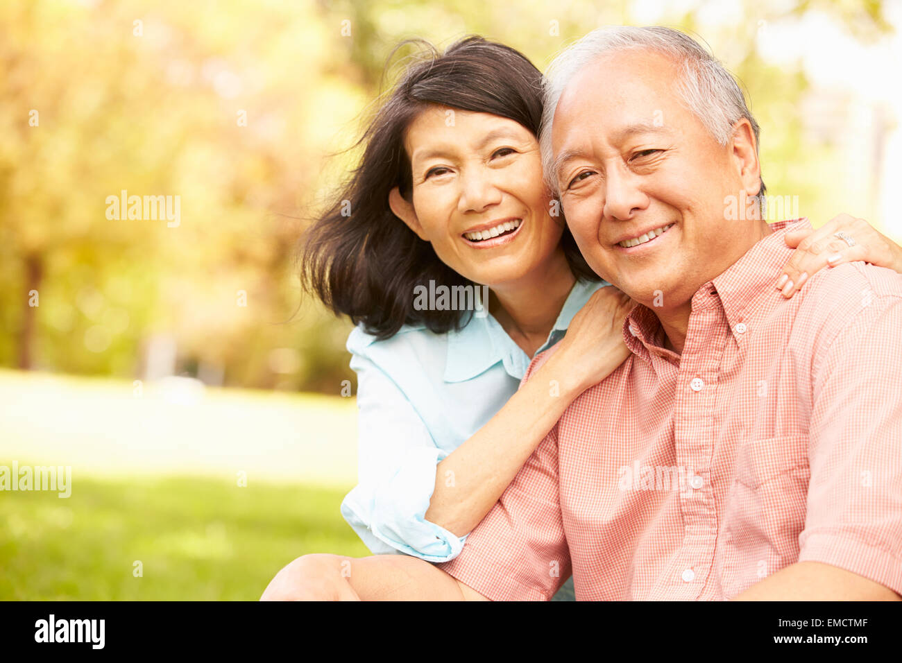 Portrait Of Senior Asian Couple Sitting In Park Together Stock Photo ...
