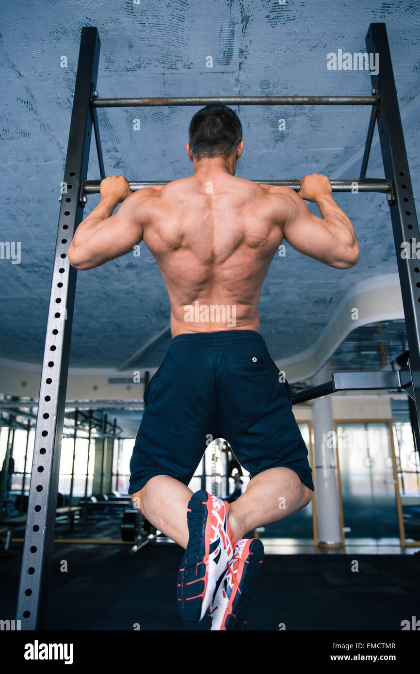 Back view portrait of a muscular handsome man pulling up at gym Stock ...