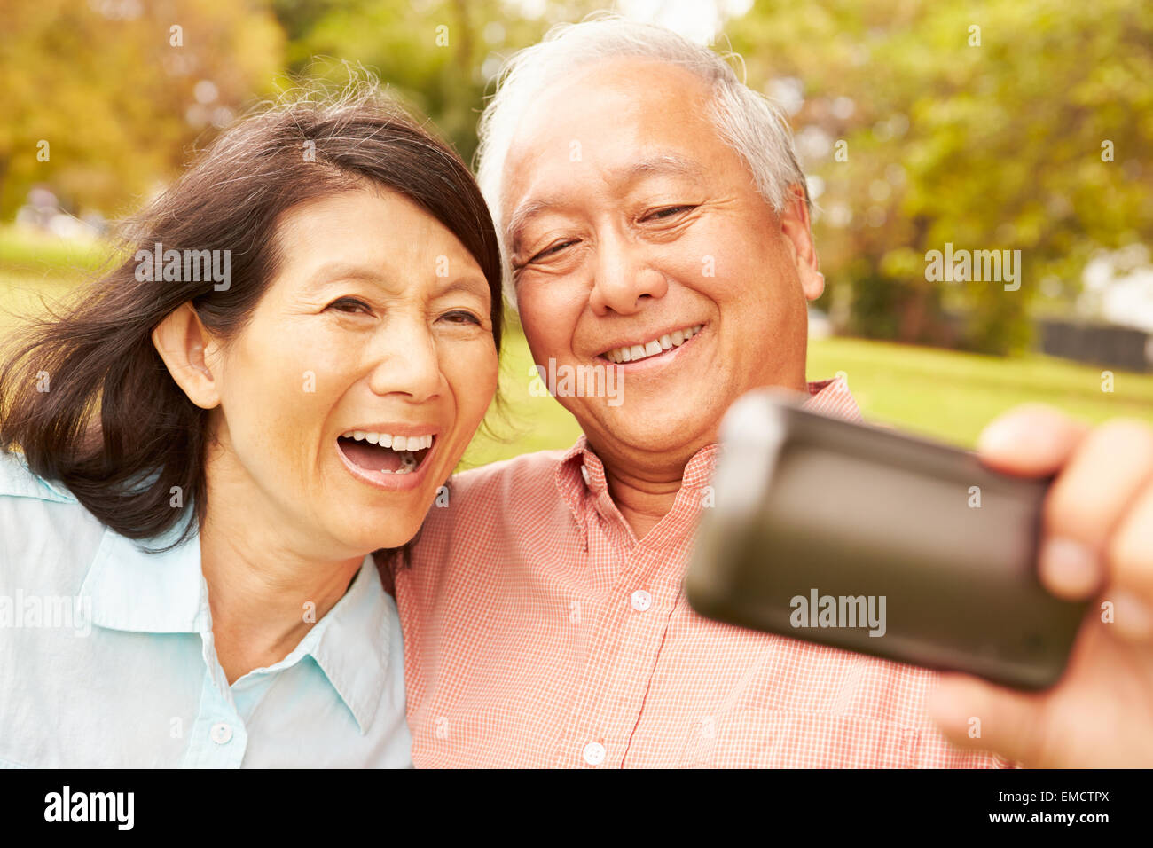 Senior Asian Couple Taking Selfie In Park Together Stock Photo - Alamy