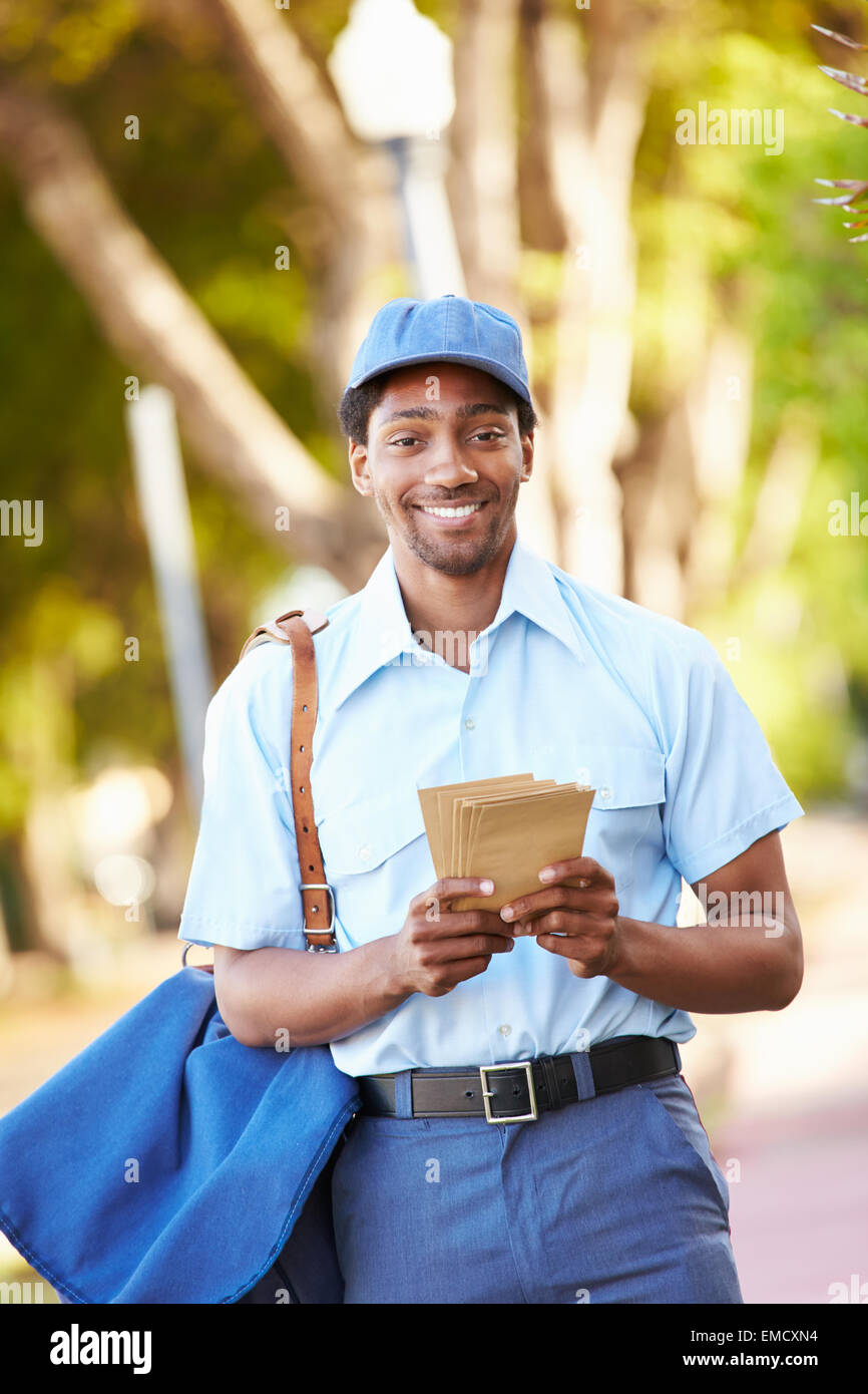 Mailman Walking Along Street Delivering Letters Stock Photo