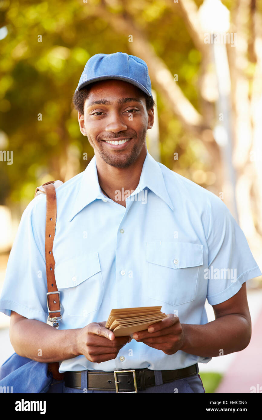 Mailman Walking Along Street Delivering Letters Stock Photo