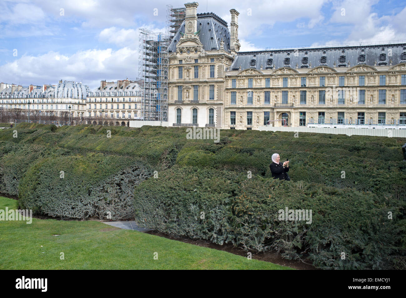 A woman takes a  picture in Tuileries Gardens in Paris Stock Photo