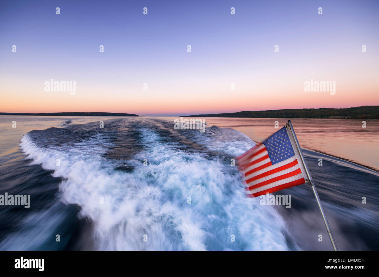USA, Michigan, sunset, US Flag, Boat Wake Stock Photo