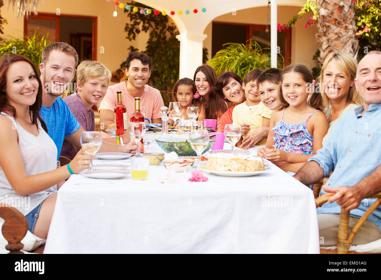 Large Family Group Enjoying Meal On Terrace Together Stock Photo
