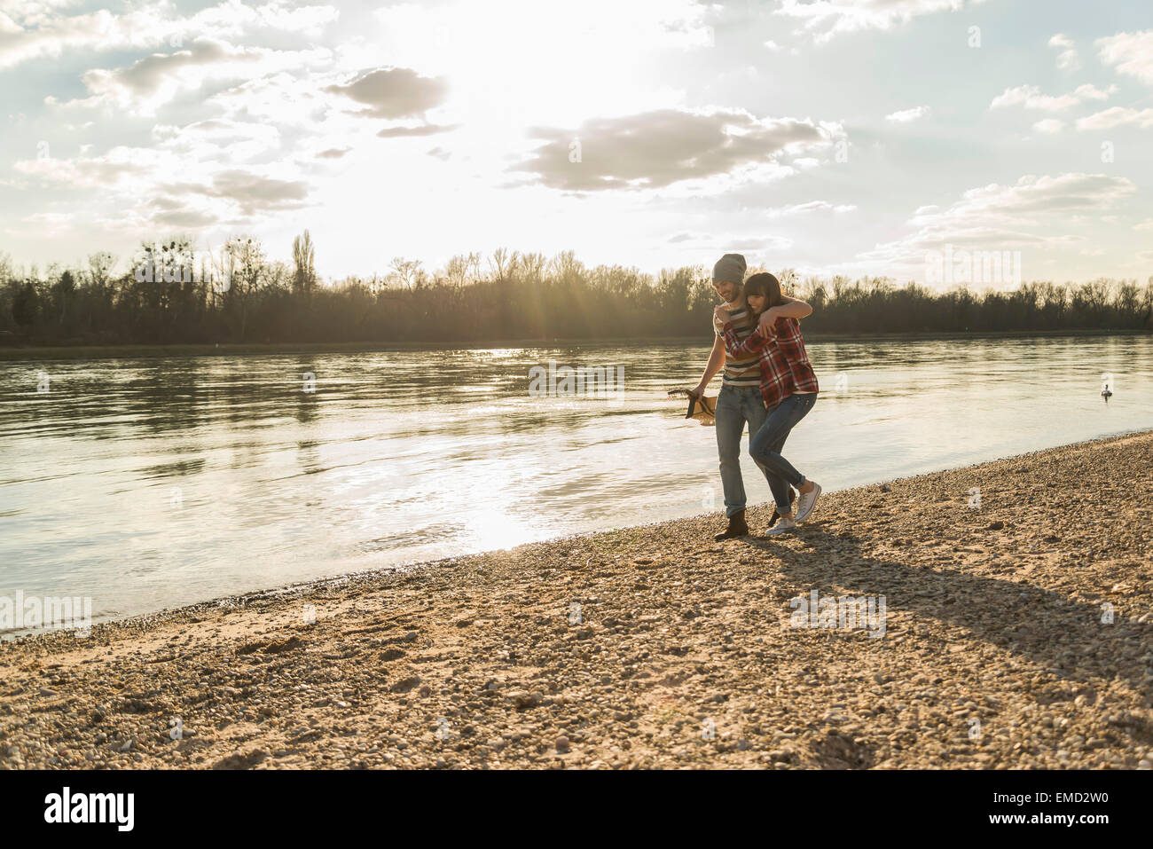 Happy young couple walking at the riverside Stock Photo - Alamy
