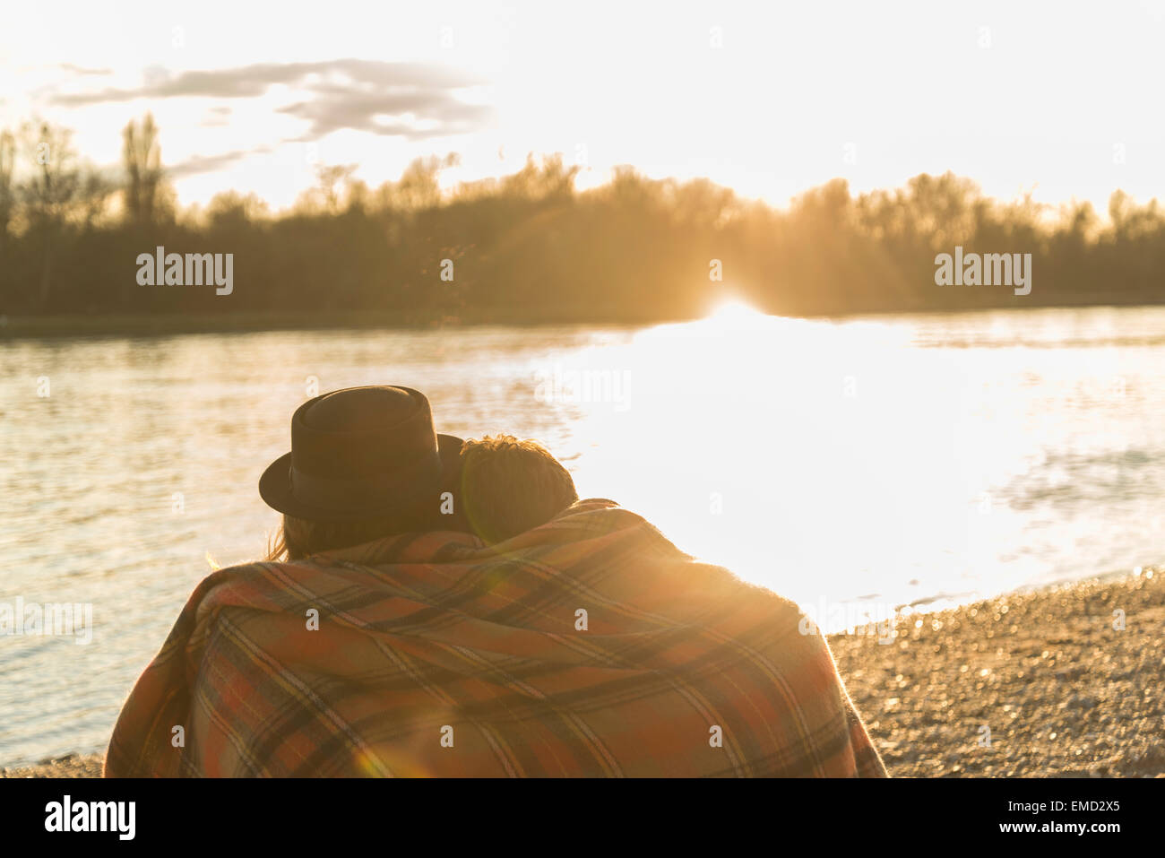 Couple at the riverside enjoying sunset Stock Photo