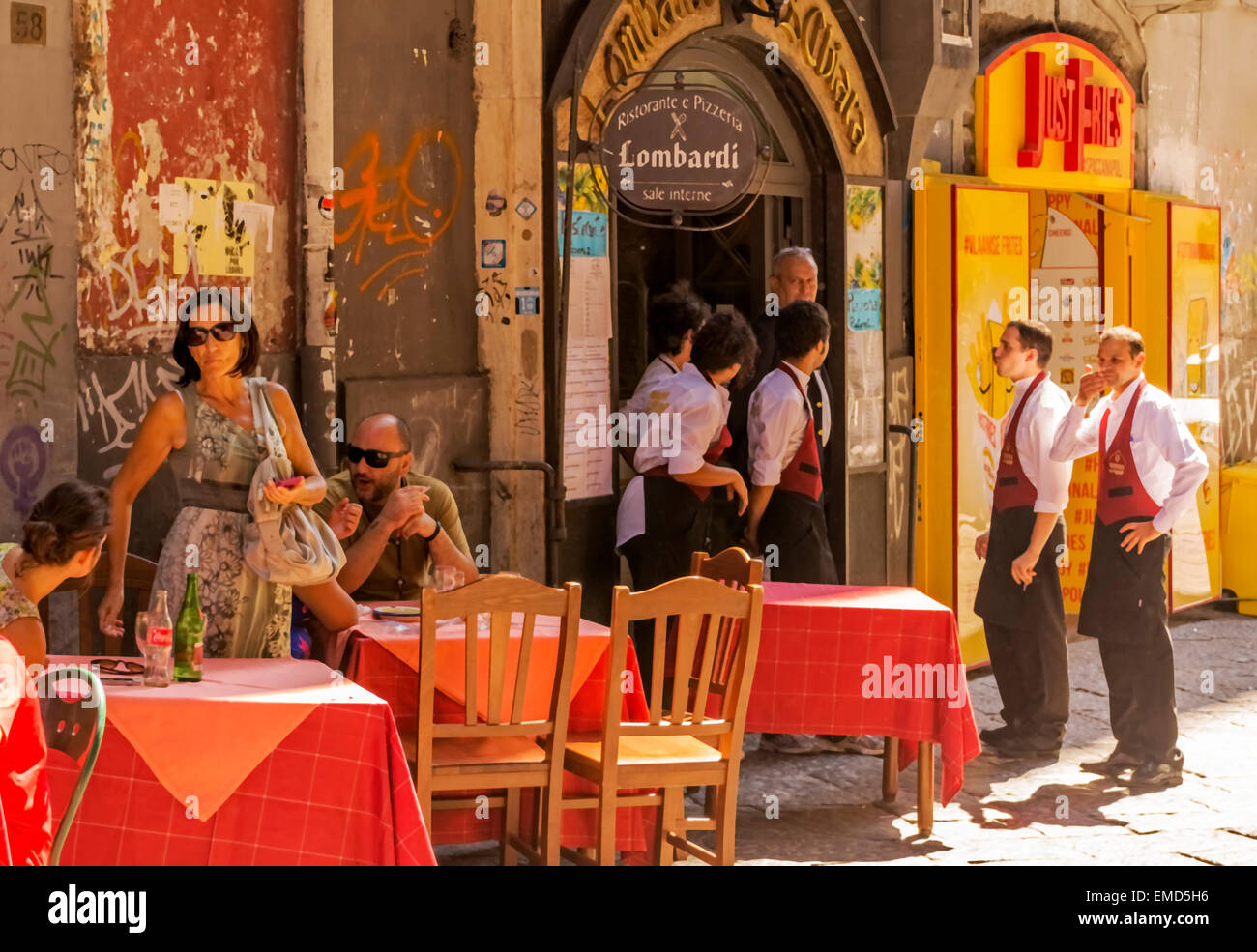 Waiters and customers / patrons outdoors at a Pizza restaurant in the old town area of Naples. Stock Photo
