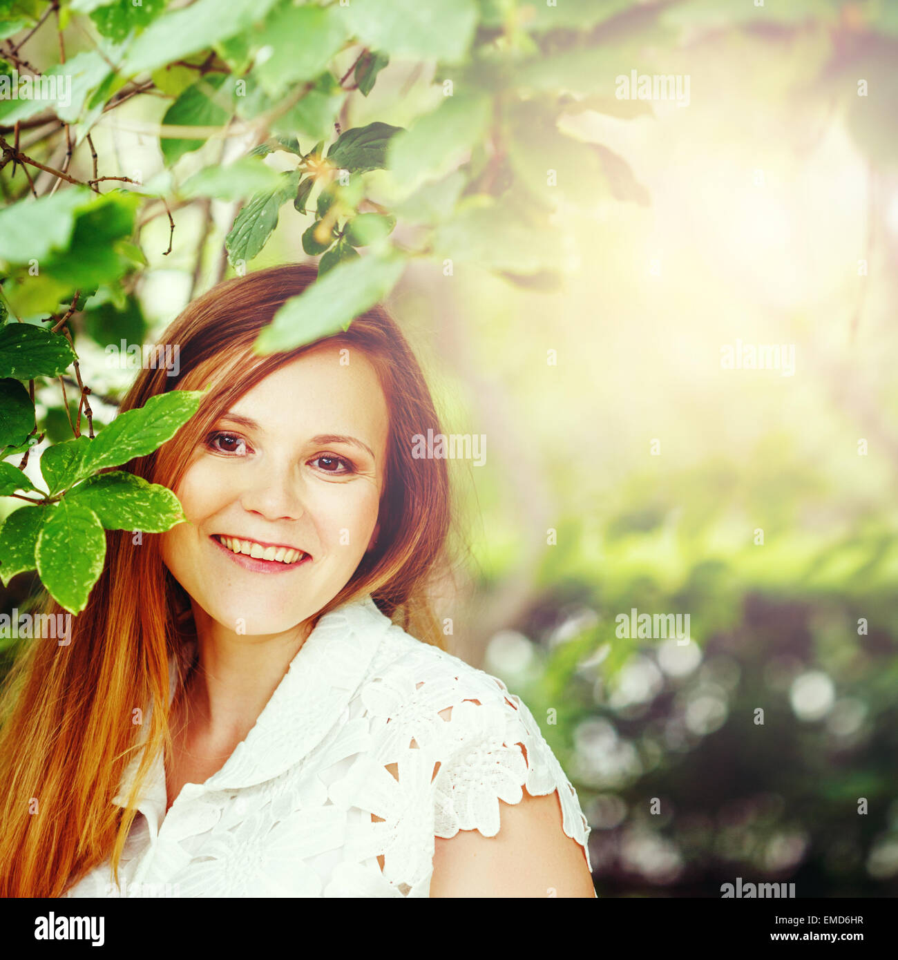 Beautiful Red Hair Woman smiling against the Nature Green Background. Summer relaxation. Image toned with Cyan Colors. Stock Photo