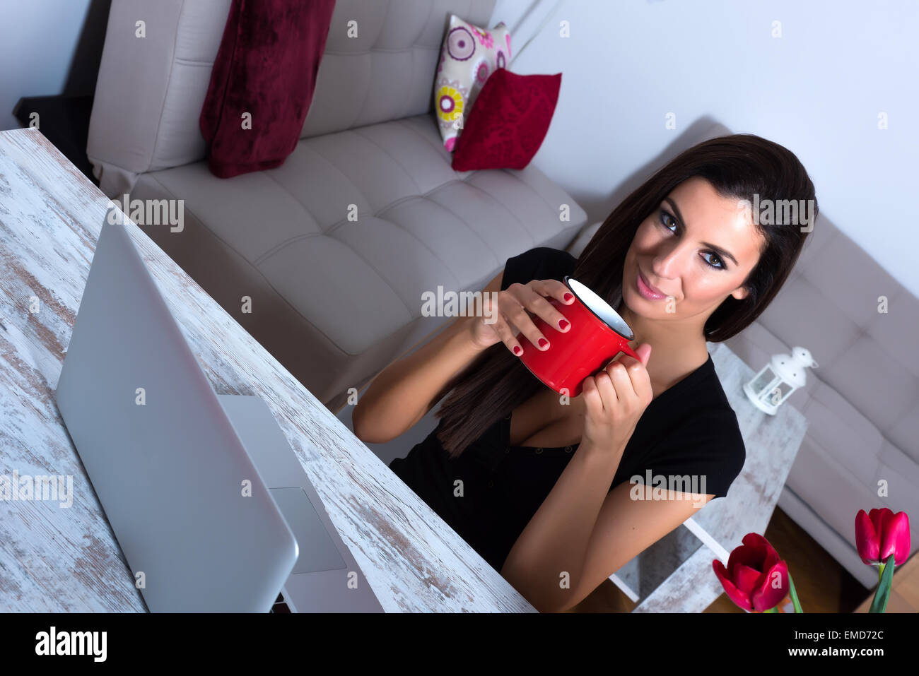 A young beautiful woman using a Laptop computer at home at night time ...
