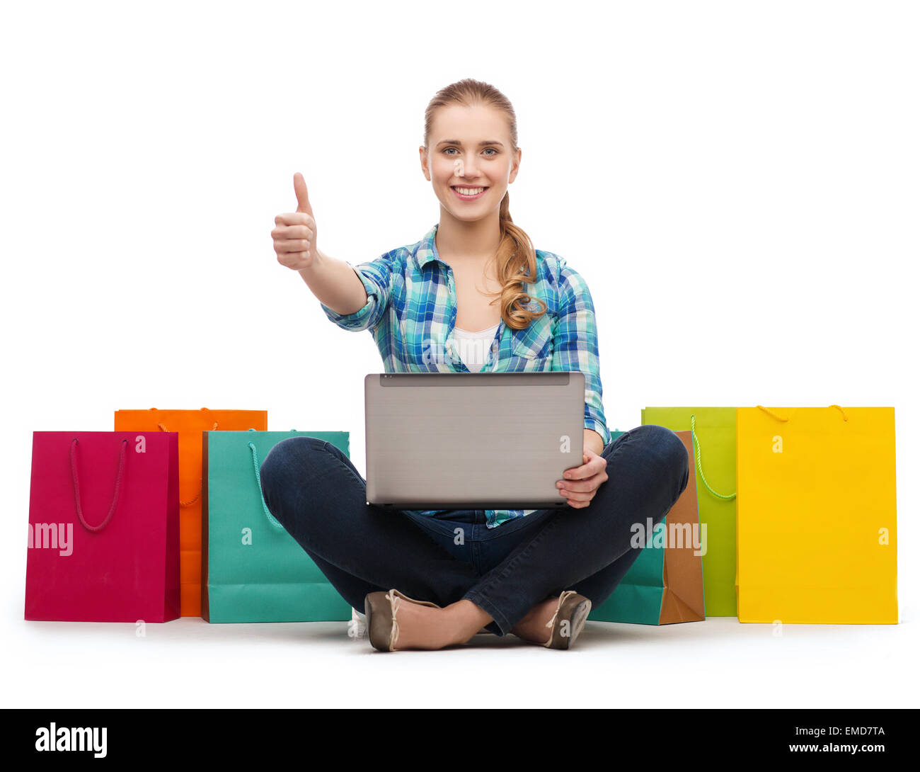 smiling girl with laptop comuter and shopping bags Stock Photo