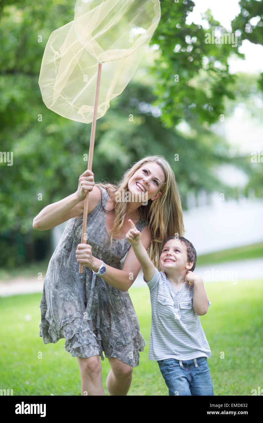 Mother and son catching butterflies with a net Stock Photo