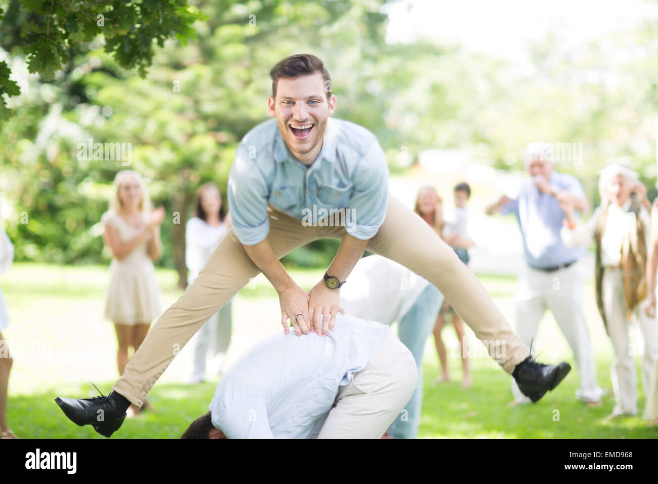 Happy young man playing leapfrog in park Stock Photo